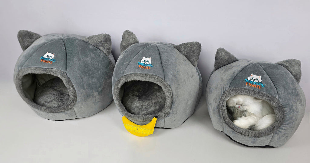 Three gray cat-shaped pet beds with a small white cat inside one of them on a light gray background.