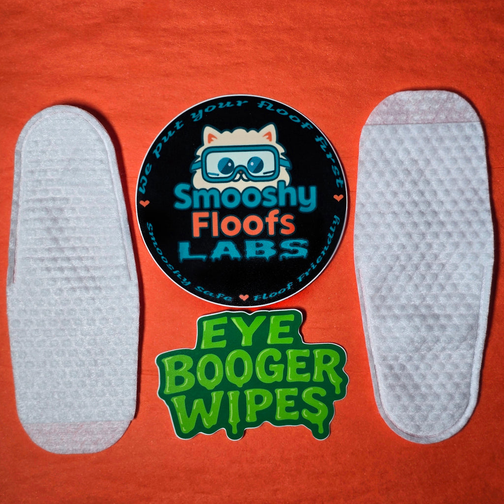 Eye booger wipes with 'Smooshy Floofs Labs' branding on an orange background