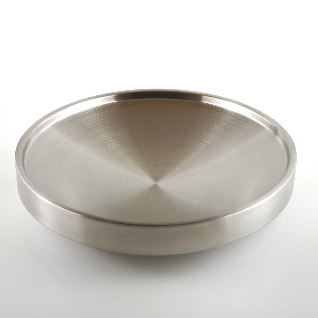 Metallic circular plate on a gray background