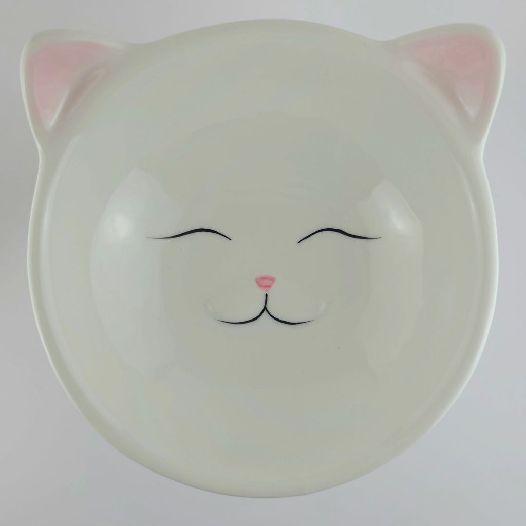 Ceramic bowl with cat face design on a white background