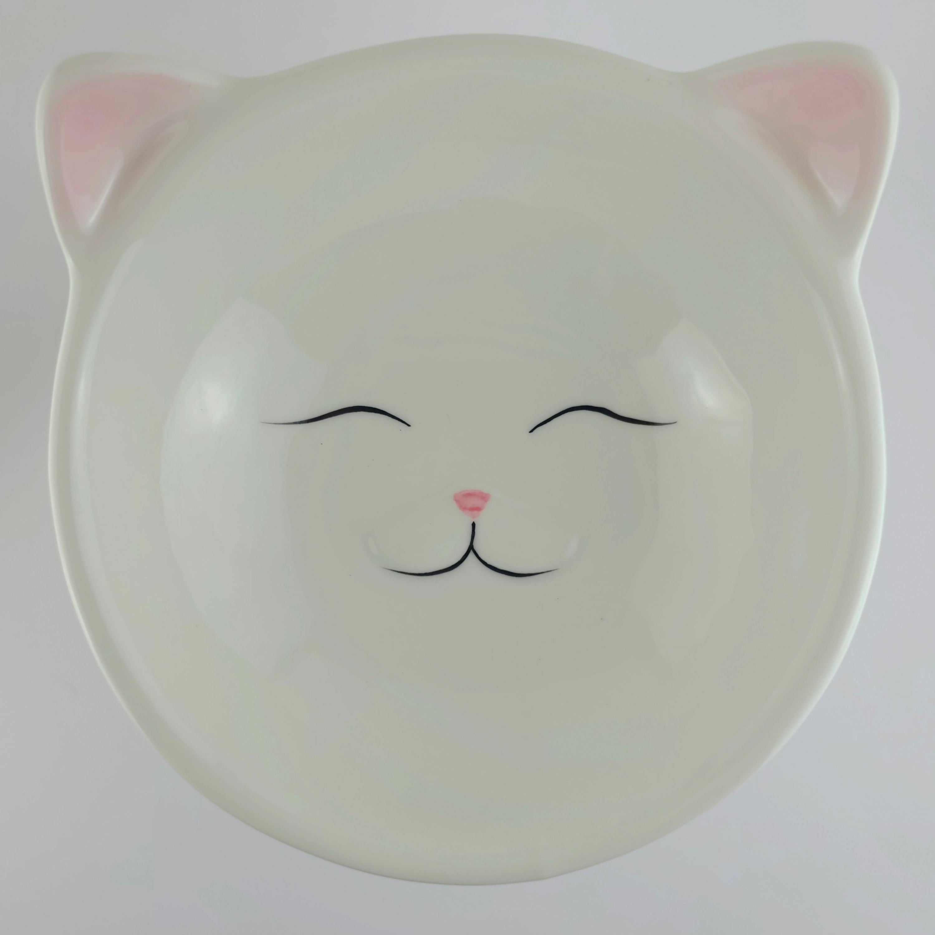 Ceramic bowl with cat face design on a white background