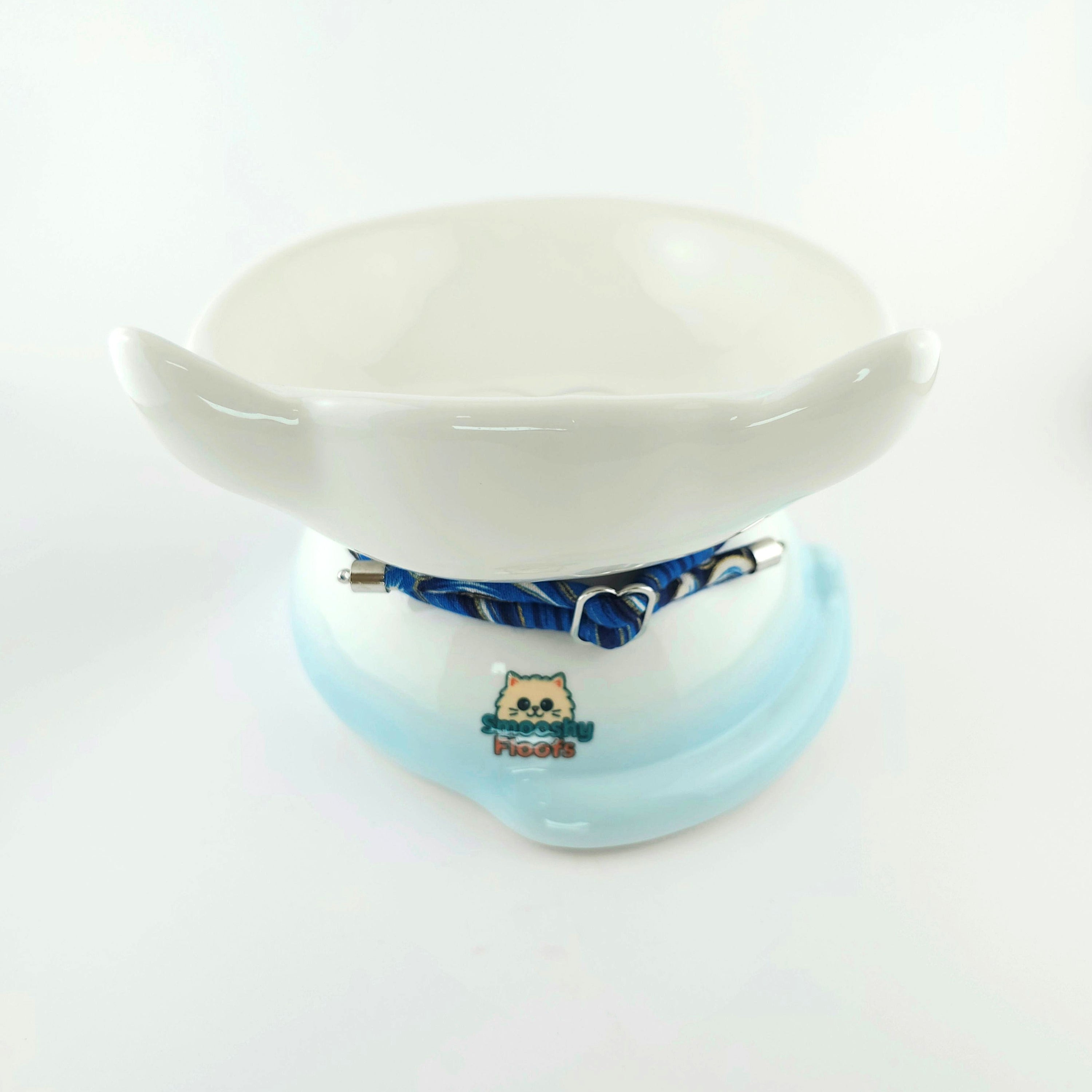 White ceramic bowl with blue base and decorative element on a white background