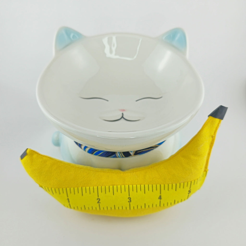 Cat-shaped bowl with a yellow measuring tape on a white background