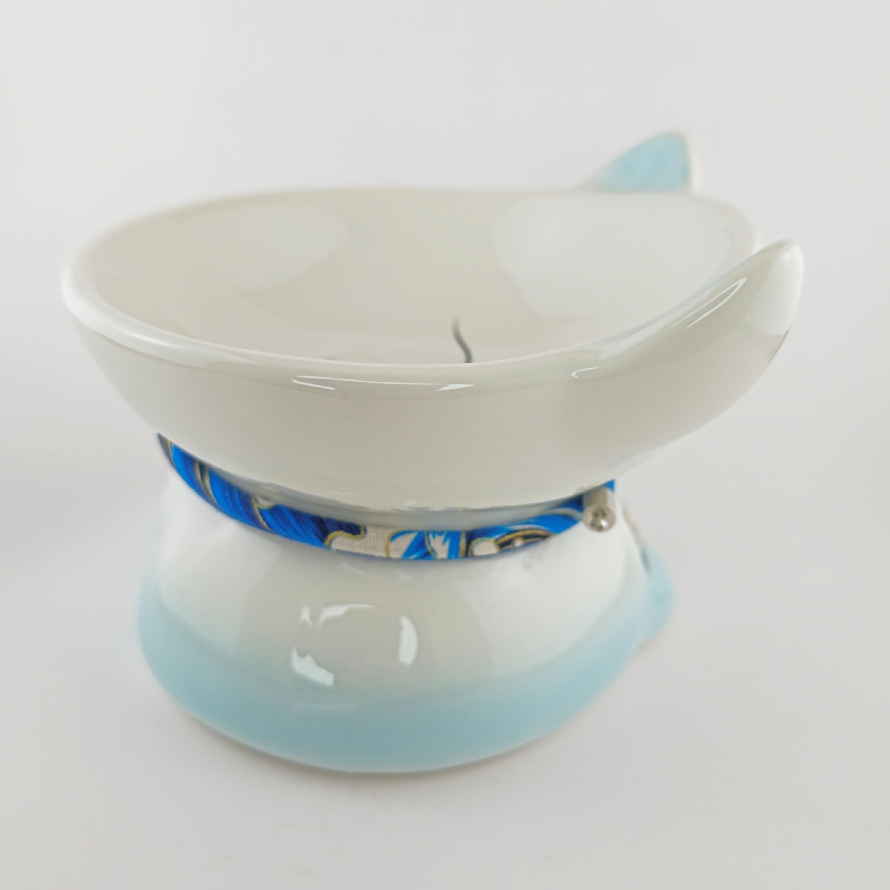 White ceramic bowl with blue interior on a white background
