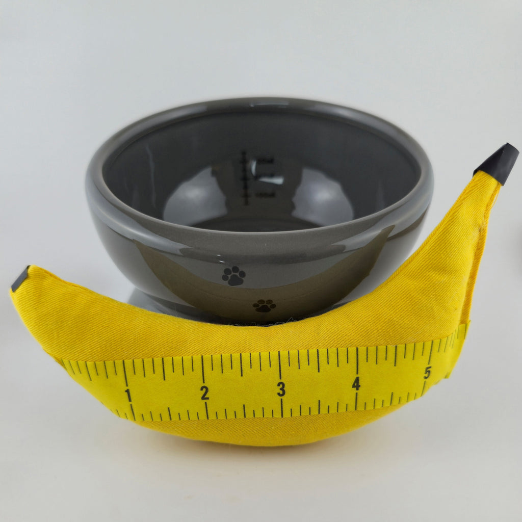 Gray bowl with a yellow banana on a white background