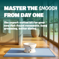 A pet grooming kit setup in a bright room, featuring a white elevated bowl on a blue mat with promotional text overlay reading 'MASTER THE SMOOSH FROM DAY ONE'.